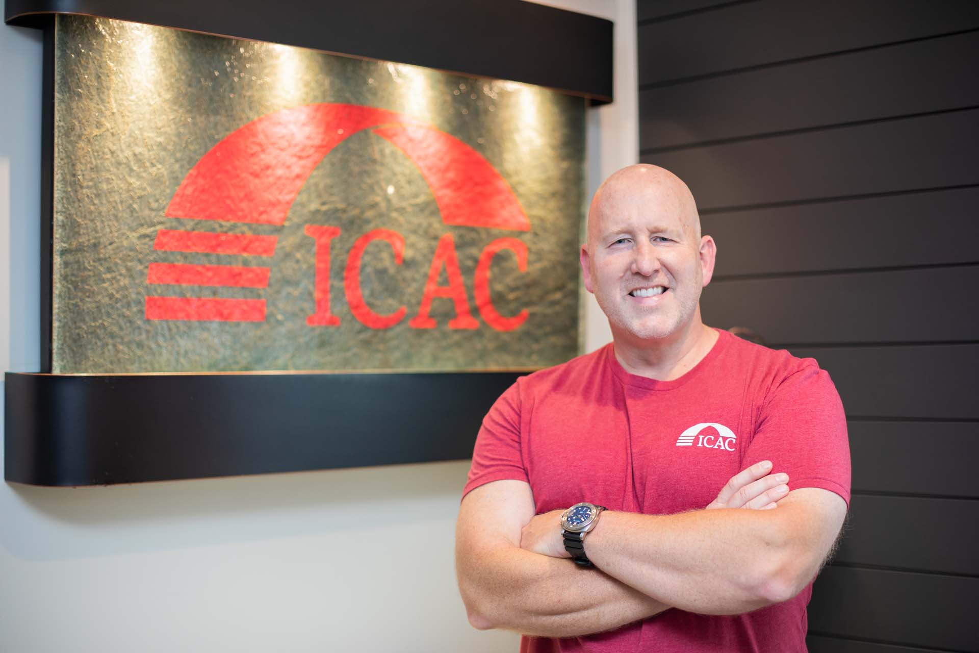 Dr. Frank Pugh of ICAC posing in front of the office logo